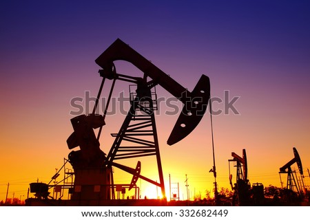 Oil field scene, the evening of beam pumping unit in silhouette