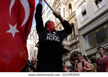 ISTANBUL, TURKEY - MAY 31, 2014: Undefined demonstrator waving the Turkish flag during the demonstration for the anniversary of the first year of Gezi park in Taksim Square, Istanbul, Turkey.