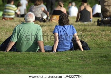people sitting on grass during an outdoor event in a field