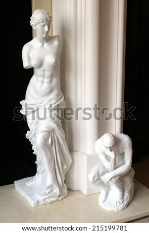 statue of armless woman and a thinking man