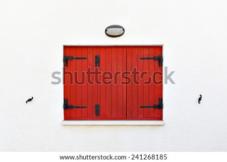 Old fashioned red wooden window shutters closed