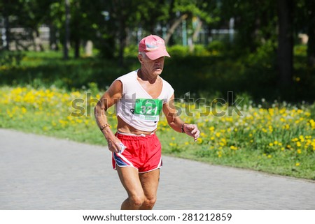 OMSK, RUSSIA - MAY 24 : Marathon runner competes at the Spring Half Marathon 2015 in Omsk, Russia, May 24,  2015. Marathon old male athlete running on street.