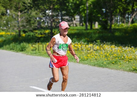 OMSK, RUSSIA - MAY 24 : Marathon runner competes at the Spring Half Marathon 2015 in Omsk, Russia, May 24,  2015. Elderly male marathon athlete running on street.