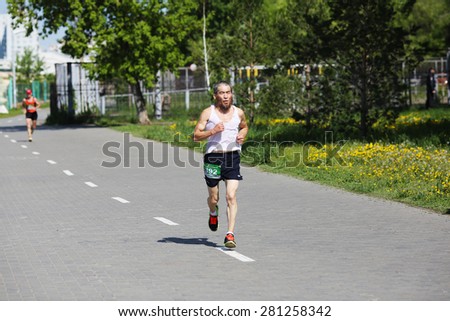 OMSK, RUSSIA - MAY 24 : Marathon runner compete at the Spring Half Marathon 2015 in Omsk, Russia, May 24,  2015. Marathon athletes running on street.