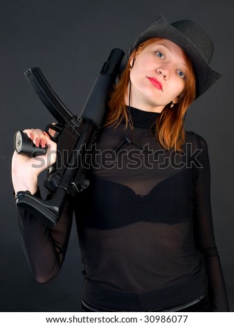 Sexy red young woman in a cowboy hat holding the gun