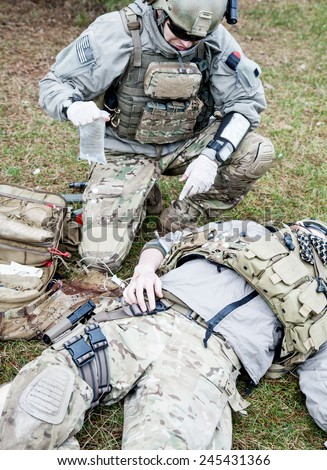 United States Army ranger treating the wounds of his injured fellow in arms