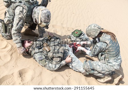 United States paratroopers airborne infantrymen in the desert rescuing their brother