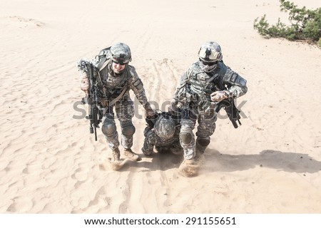 United States paratroopers airborne infantrymen in the desert rescuing their brother