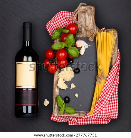 Italian Food. Italian pasta ingredients and bottle of wine on black slate board.