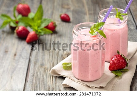 Fruit smoothie with mint leaves on wooden rustic table. Tilt-Shift. Focus on jars.