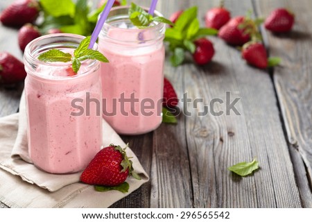 Fruit smoothie with mint leaves on wooden rustic table.
