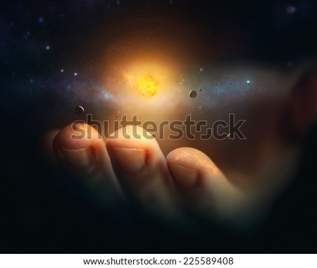 A miniature universe rests on the finger tips of a hand.