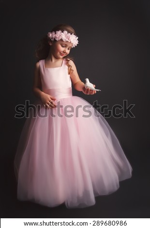 Pretty little girl holding little bird in hands