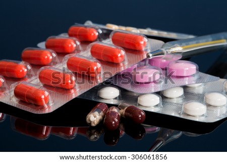 colorful capsules and pills closeup on white