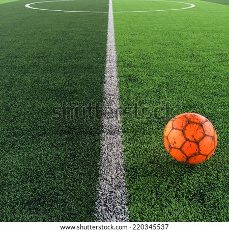 A football on artificial grasses in an indoor stadium