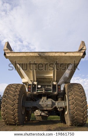 Back of huge dump truck showing big wheels and carrying box.
