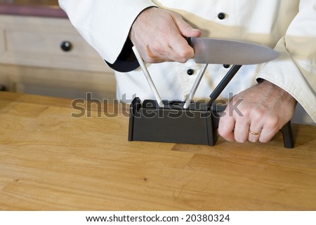 Chef sharpening his knife using sharpening tool