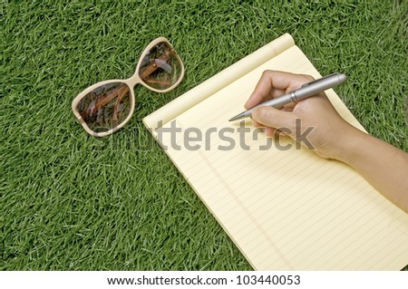 People writing on the paper over green grass. You can write your message on the paper