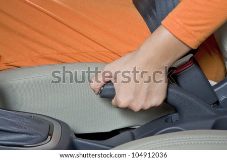 Woman hand pull hand brake of a car