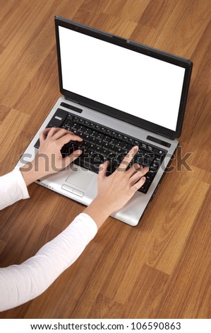 Woman hand writing with laptop computer on the wooden floor