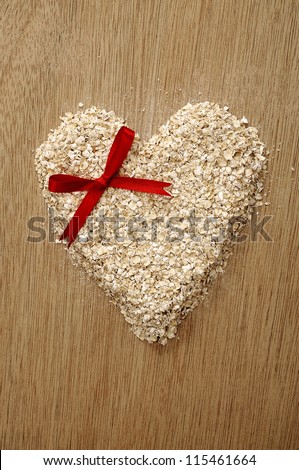 Heart shape oatmeal on wooden background. Good for healthy food concept