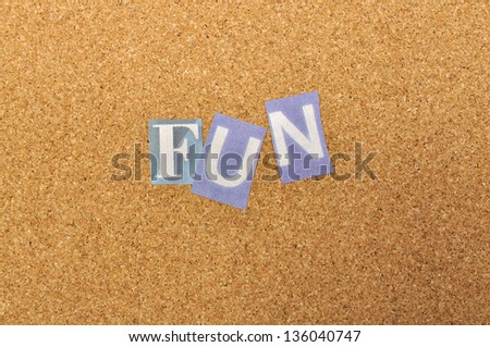 Fun word made from newspaper letter shot over pinboard background