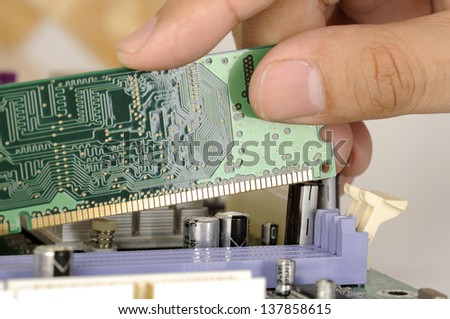 Man hand install memory card board on the computer motherboard