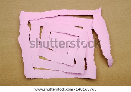 Torn pink paper scraps on brown cardboard background. You can put your design on the paper