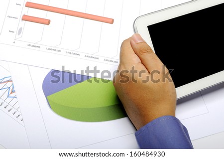 Business man holding tablet. Analyze sales and profit. You can put your design on the screen