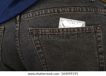 Condom inside pocket of man pants. Contraceptive concept