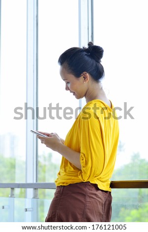 Asian business woman using cellphone in her office
