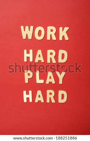 Work hard play hard text on red paper background