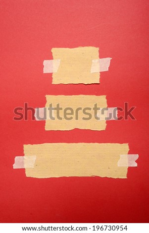 Torn paper with tape on red paper background