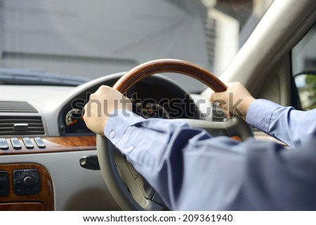 Close up of man hand holding a steering wheel in a car