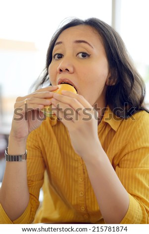 Pretty Young Woman Eating Burger Enjoying Break Lunch In Cafe