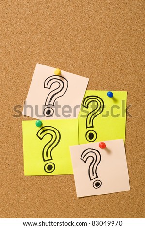 Question Marks writing on the paper attached on cork board