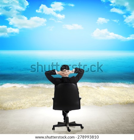 Young businessman relaxing on the beach. The office floor transform into beach