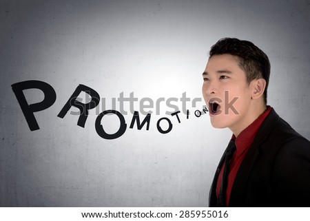 Asian business man shout promotion over grunge wall