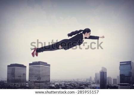 Asian business woman flying over the city