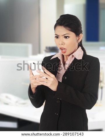 Asian woman surprise looking at her cellphone. Business surprise conceptual