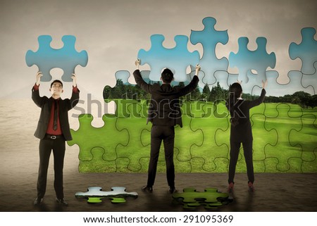 Business teamwork assembling puzzle pieces create green environment. Green industry concept