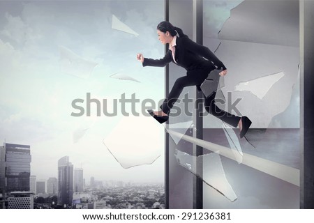 Business woman jump through office window glass. Business freedom concept