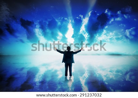 Business man standing on the sea looking at the sky