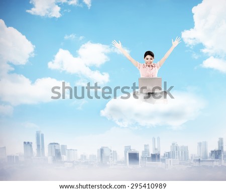 Business woman working on the cloud above the city. Cloud computing concept