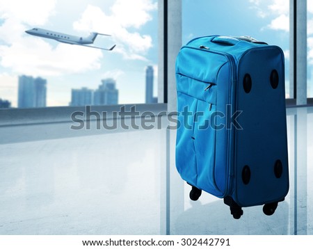 Travel bag on the airport with plane on the background