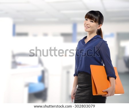 Asian business woman holding folder, smiling with office background