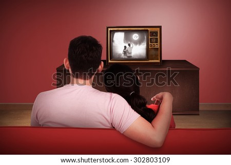Young asian couple watching retro tv in the house