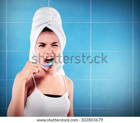 Woman with great teeth holding tooth-brush on bathroom background
