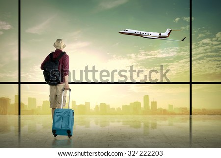 Asian man wearing hat carry suitcase. Business travel concept
