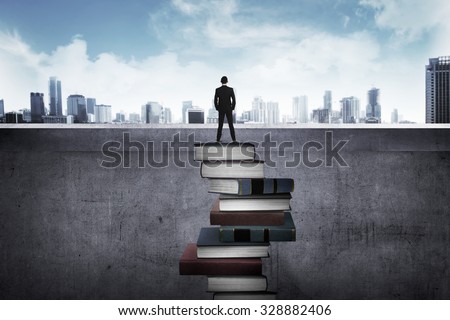 Back view business person looking the city, standing on the top of the book. Education for success concept